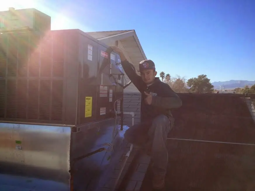 HVAC technician performing HVAC Inspection on a rooftop unit in Watauga